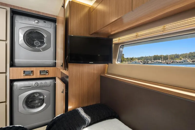 Slide: The Image of Interior of 2017 Sea Ray L590 Sport yacht with washer, dryer, TV, and scenic window view. - 32
