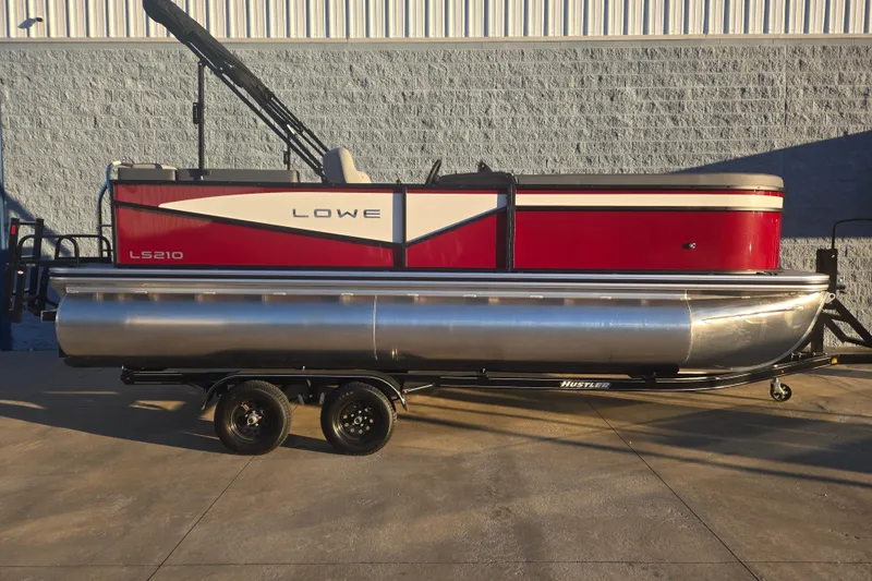 Slide: The Image of 2025 Lowe LS210WT pontoon boat on trailer, red and silver design. - 0