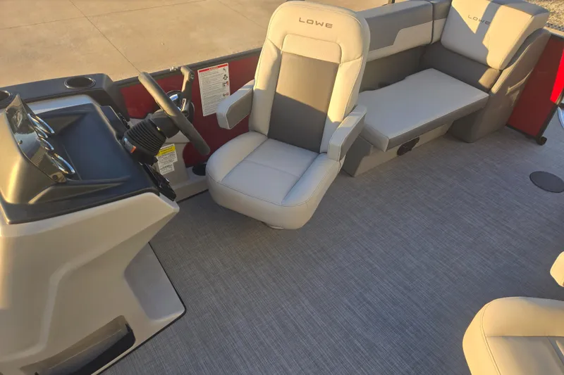 Slide: The Image of 2025 Lowe LS210WT boat interior with steering console and cushioned seating. - 6