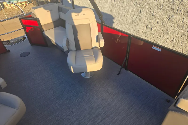 Slide: The Image of 2025 Lowe LS210WT boat interior with beige seating and red panel accents. - 7