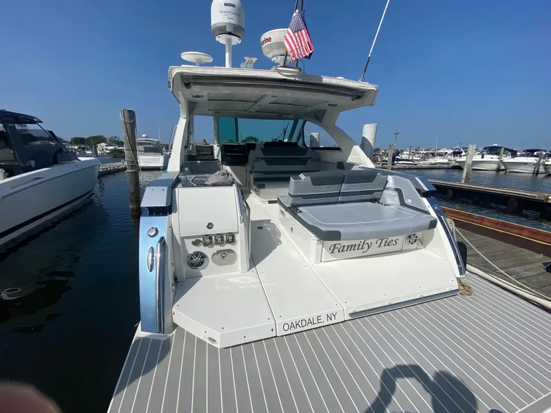 Slide: The Image of 2020 Formula 380 Super Sport Crossover boat docked, rear view with seating and American flag. - 5