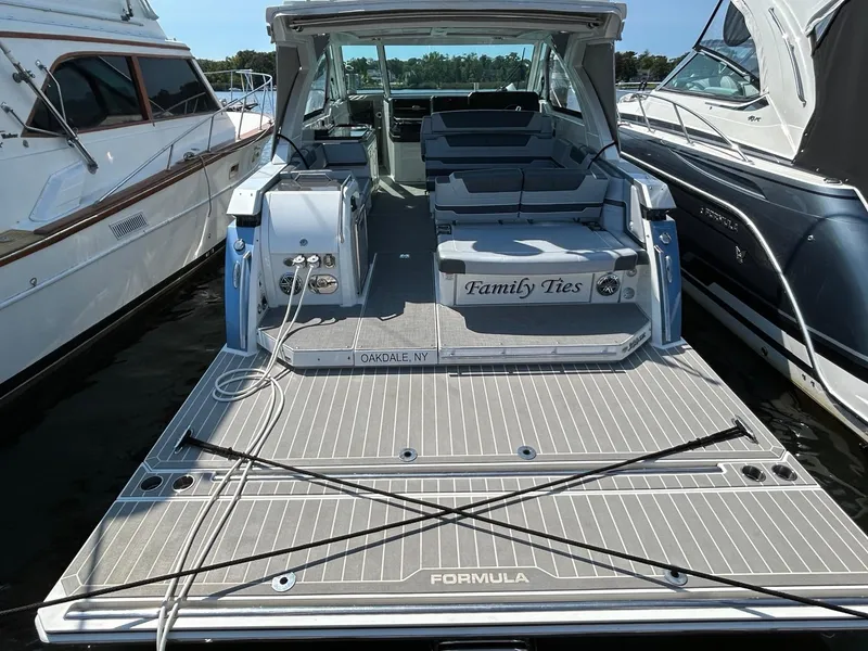 Slide: The Image of 2020 Formula 380 Super Sport Crossover boat docked, rear view with seating area. - 6