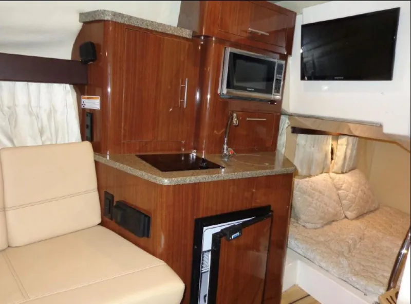 Slide: The Image of Interior of 2014 Regal 28 Express boat with kitchenette and seating area. - 10