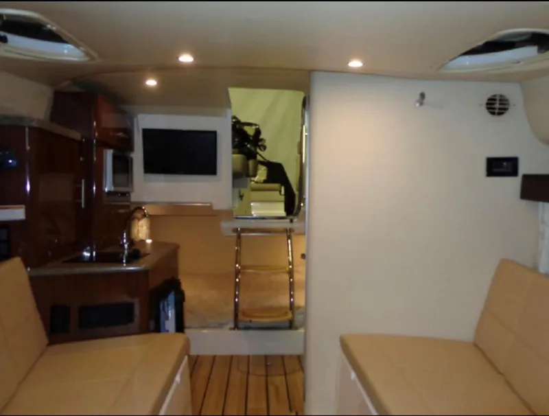 Slide: The Image of Interior of 2014 Regal 28 Express boat with seating, kitchenette, and TV. - 11