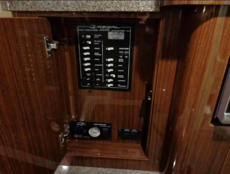 Slide: The Image of Control panel inside 2014 Regal 28 Express boat, featuring switches and gauges. - 12