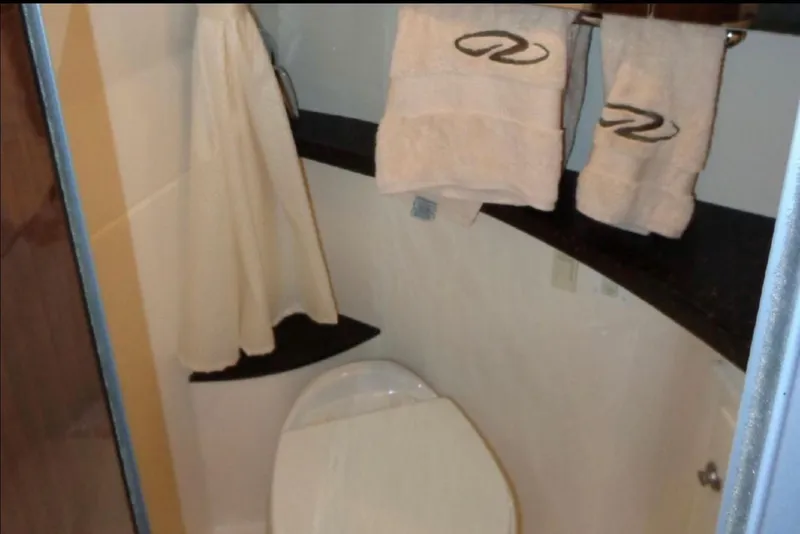 Slide: The Image of Bathroom interior of 2014 Regal 28 Express boat with towels and toilet. - 13