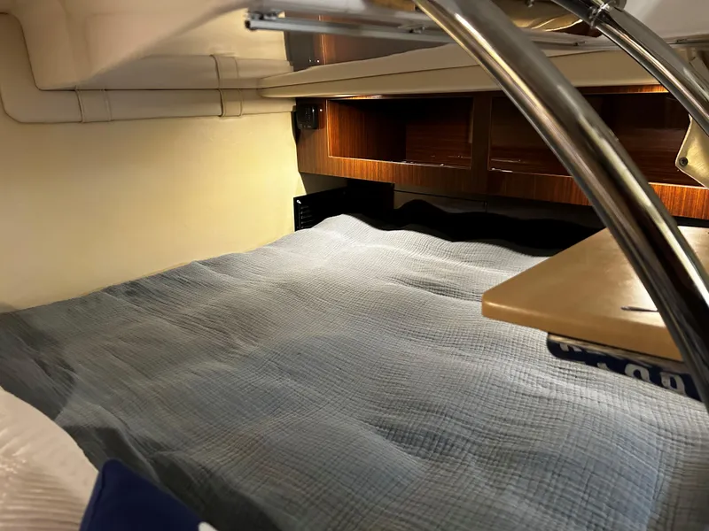 Slide: The Image of 2014 Regal 28 Express cabin interior with cozy bedding and wooden storage. - 16