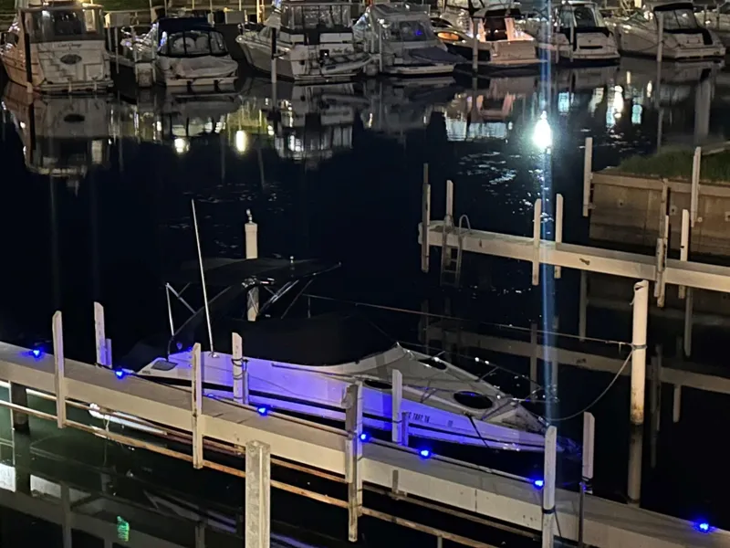 Slide: The Image of 2014 Regal 28 Express boat docked at night with illuminated blue lights. - 18