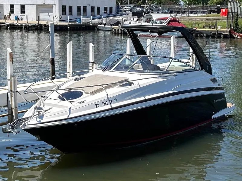 Slide: The Image of 2014 Regal 28 Express boat docked in a marina, featuring sleek design and modern amenities. - 2