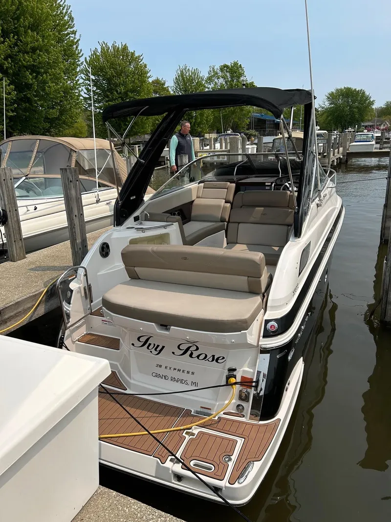 Slide: The Image of 2014 Regal 28 Express boat docked, featuring spacious seating and sleek design. - 20