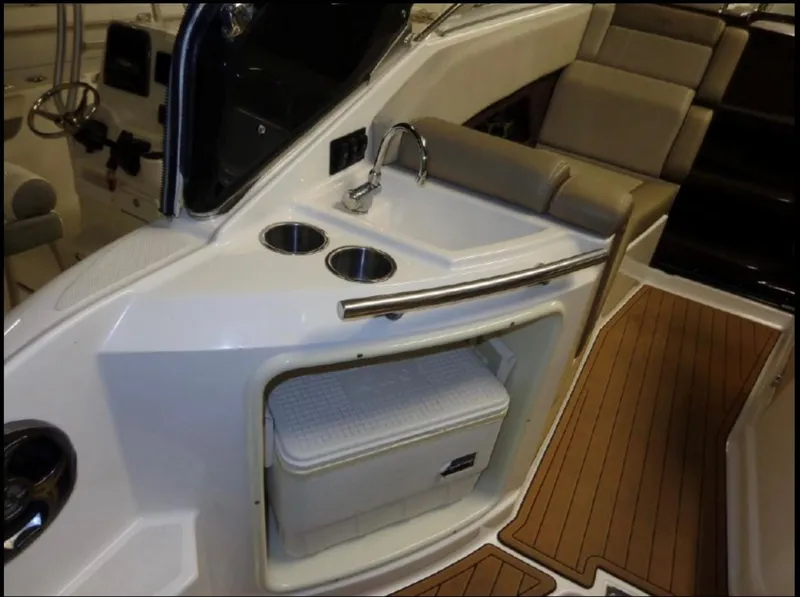 Slide: The Image of 2014 Regal 28 Express boat interior with sink, cup holders, and storage compartment. - 7