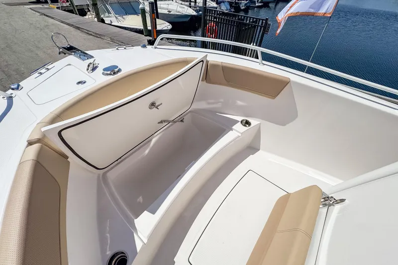 Slide: The Image of Edgewater 208CC 2025 boat with open storage hatch at dock. - 9
