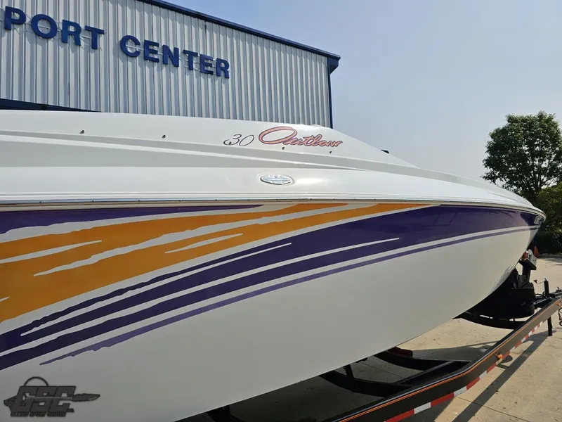 Slide: The Image of 2004 Baja 30 Outlaw boat with colorful graphics at a port center. - 12