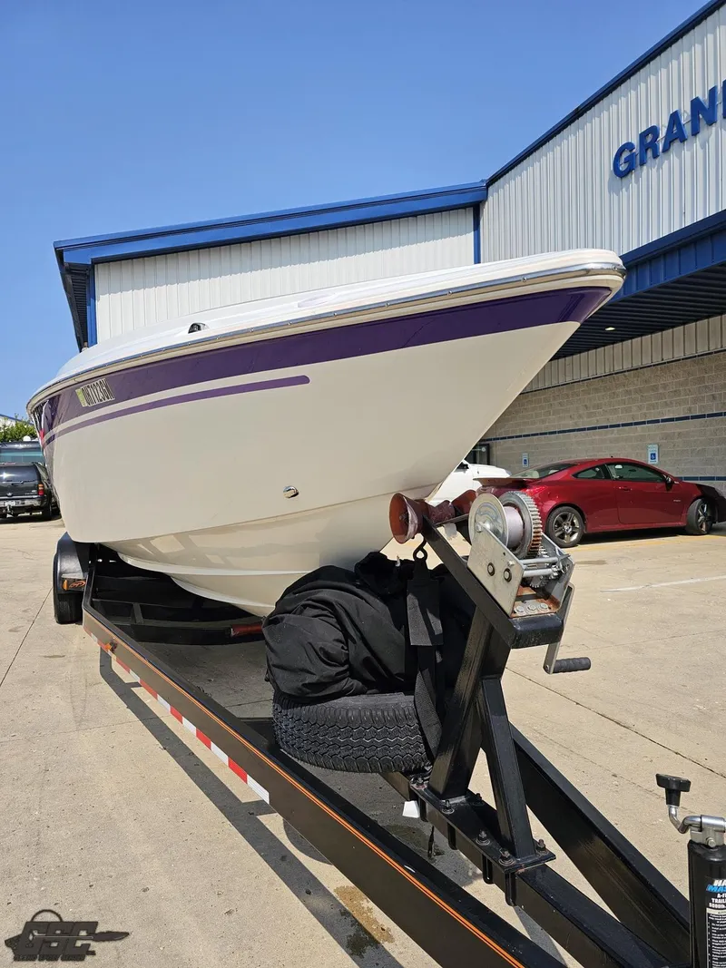 Slide: The Image of 2004 Baja 30 Outlaw boat on trailer, parked outside a building. - 17