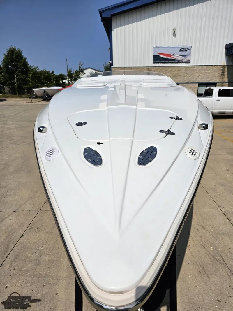 Slide: The Image of 2004 Baja 30 Outlaw boat, sleek white design, parked outdoors. - 18