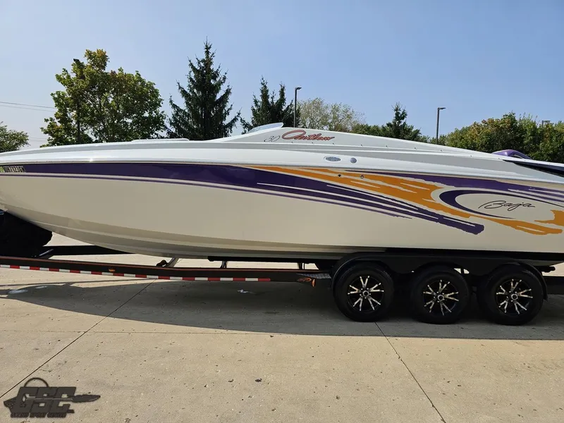Slide: The Image of 2004 Baja 30 Outlaw speedboat with vibrant purple and orange graphics on a trailer. - 25