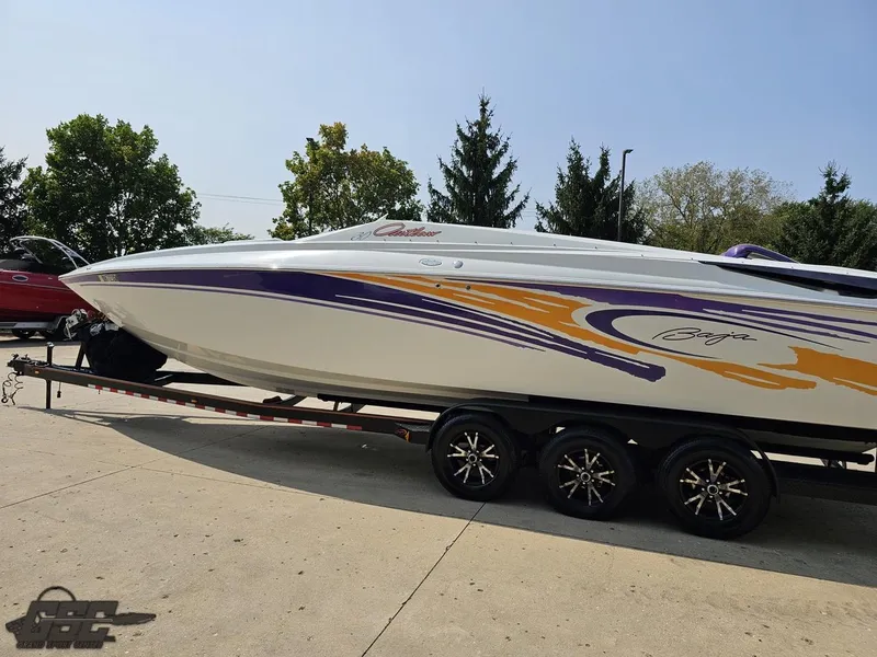 Slide: The Image of 2004 Baja 30 Outlaw speedboat on trailer, featuring vibrant purple and orange graphics. - 27