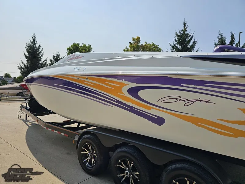 Slide: The Image of 2004 Baja 30 Outlaw boat with vibrant purple and orange graphics on a trailer. - 29