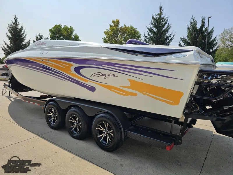 Slide: The Image of 2004 Baja 30 Outlaw speedboat with vibrant purple and orange graphics on a trailer. - 30