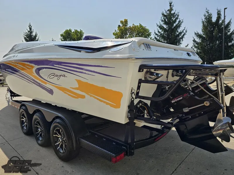 Slide: The Image of 2004 Baja 30 Outlaw boat on trailer with vibrant graphics, parked outdoors. - 31
