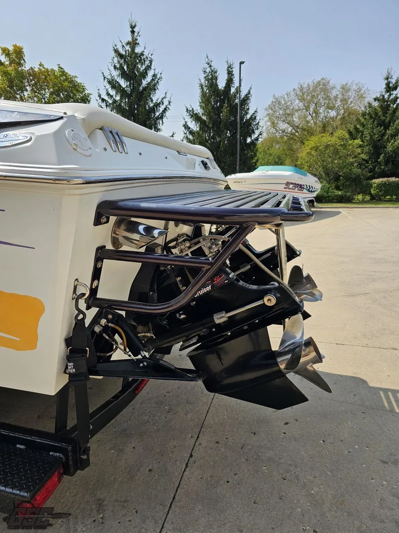 Slide: The Image of 2004 Baja 30 Outlaw boat with dual propellers, parked outdoors. - 32