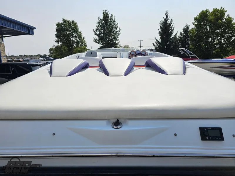 Slide: The Image of 2004 Baja 30 Outlaw boat, rear view with sleek design and trees in background. - 39