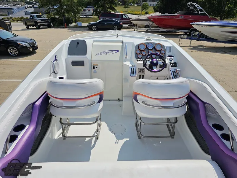 Slide: The Image of 2004 Baja 30 Outlaw boat interior with white and purple seating, dashboard, and steering wheel. - 46