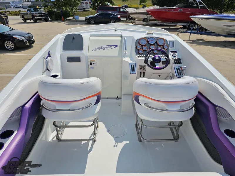 Slide: The Image of 2004 Baja 30 Outlaw boat interior with white and purple seating, dashboard, and steering wheel. - 47