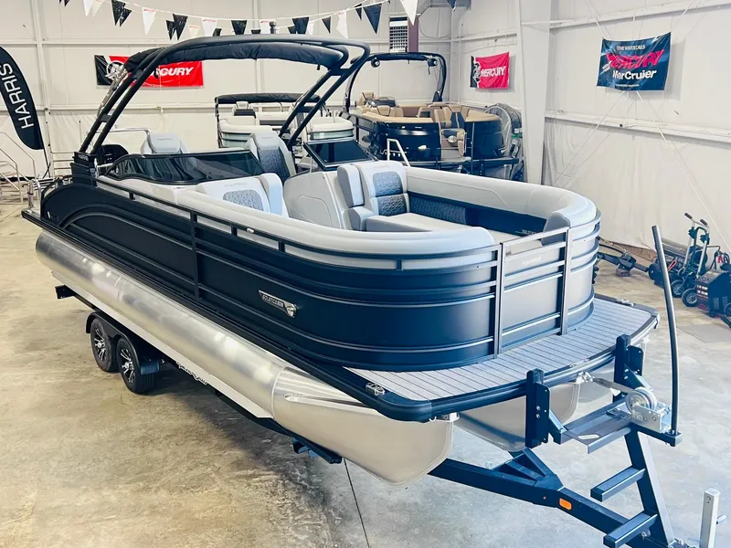 Slide: The Image of 2025 Harris Solstice DC 250 pontoon boat in showroom, sleek black design, luxury seating. - 3