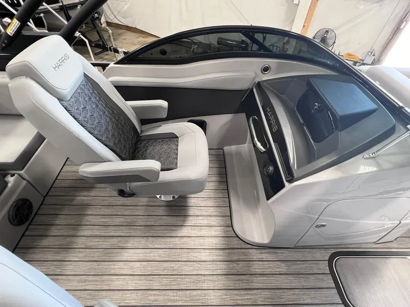 Slide: The Image of 2025 Harris Solstice DC 250 boat interior with sleek captain's chair and modern dashboard. - 9