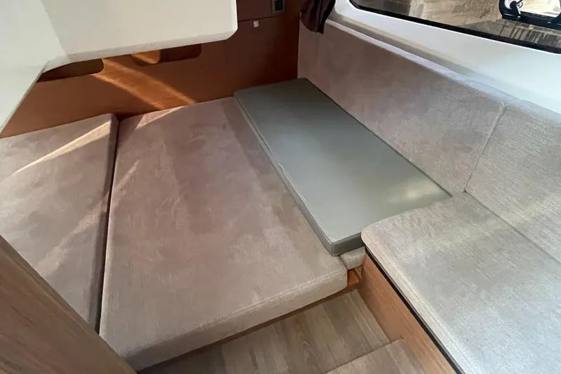 Slide: The Image of Interior cabin of 2022 Beneteau Antares 11 with beige seating and wooden accents. - 11
