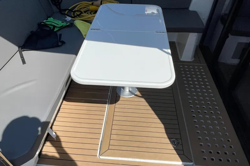 Slide: The Image of Beneteau Antares 11 (2022) boat interior with white table and cushioned seating. - 13