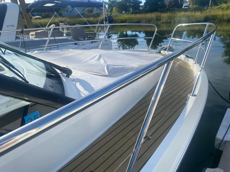 Slide: The Image of 2022 Beneteau Antares 11 boat with sleek deck and railing, docked by the water. - 20