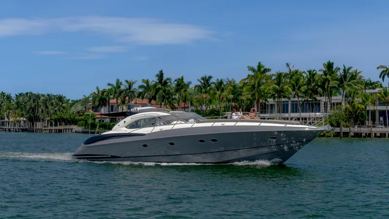 Slide: The Image of 1999 Sunseeker Predator 58 yacht cruising on a sunny day near palm-lined shore. - 19