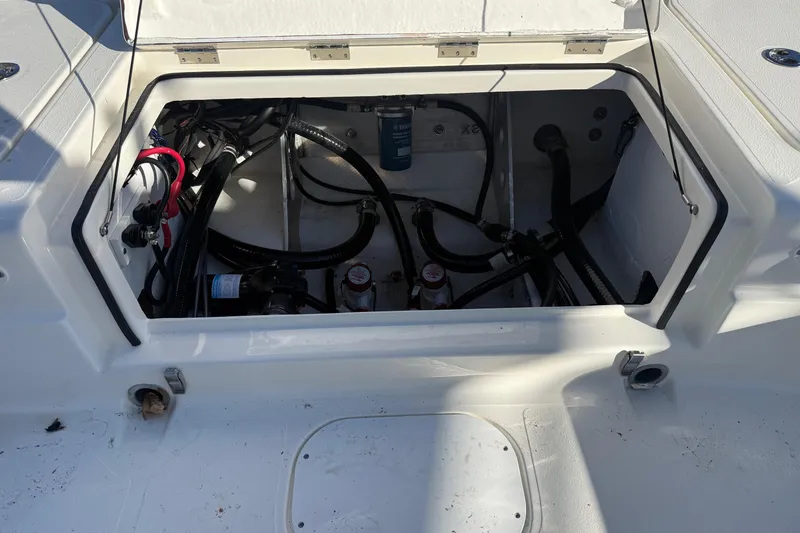 Slide: The Image of Open compartment of 2025 Skeeter SX221 boat showing internal wiring and components. - 13