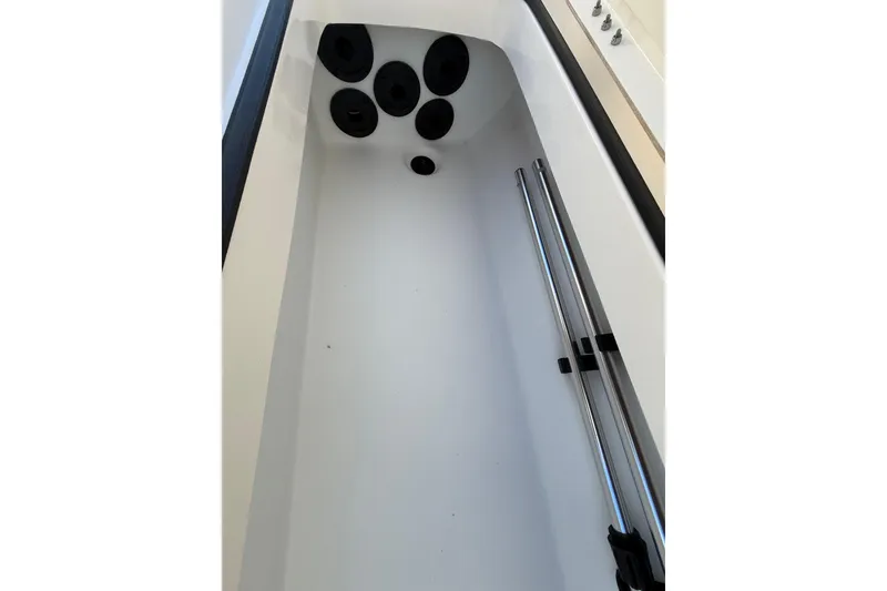 Slide: The Image of 2025 Skeeter SX221 boat storage compartment with rod holders and sleek design. - 27