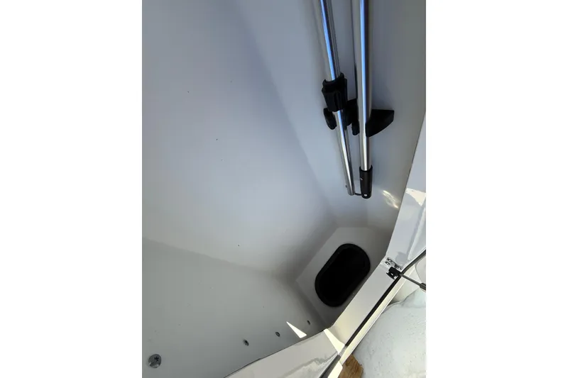 Slide: The Image of 2025 Skeeter SX221 boat storage compartment with metal poles and a small hatch. - 28