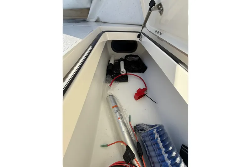 Slide: The Image of Storage compartment in 2025 Skeeter SX221 boat with various equipment and cables. - 31