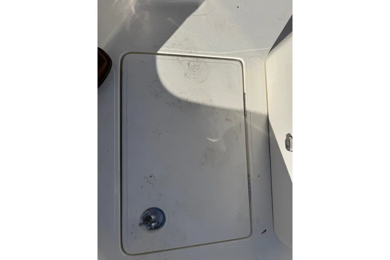 Slide: The Image of 2025 Skeeter SX221 boat storage compartment with latch, partially shaded. - 34