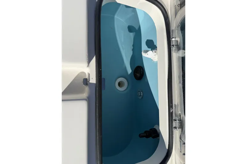 Slide: The Image of Livewell compartment of 2025 Skeeter SX221 boat, featuring blue interior and drainage system. - 36