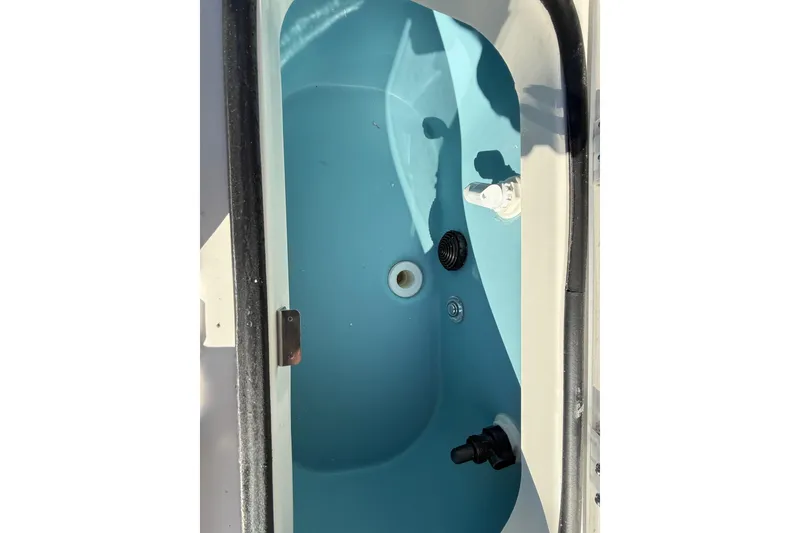 Slide: The Image of Livewell compartment of 2025 Skeeter SX221 boat, featuring blue interior and drainage system. - 37