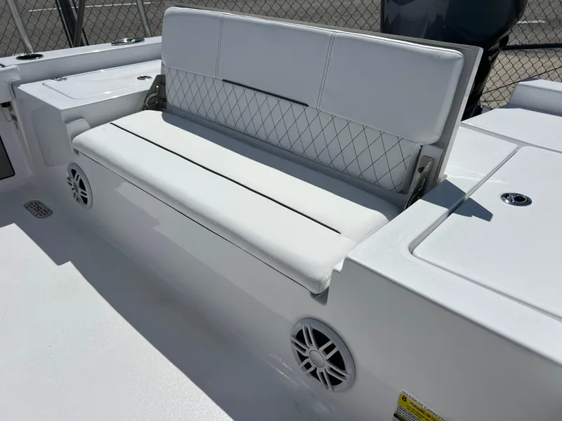 Slide: The Image of 2024 Sportsman Masters 227 Bay Boat with white cushioned seating and built-in speakers. - 12