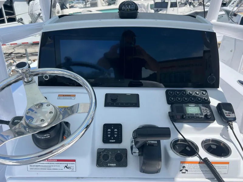 Slide: The Image of 2024 Sportsman Masters 227 Bay Boat dashboard with steering wheel and navigation controls. - 7