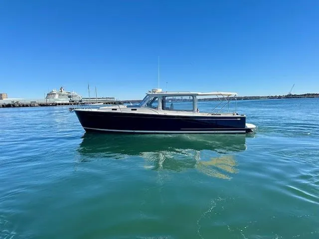 Slide: The Image of 2014 MJM 36z Downeast boat on calm blue water under clear sky. - 2