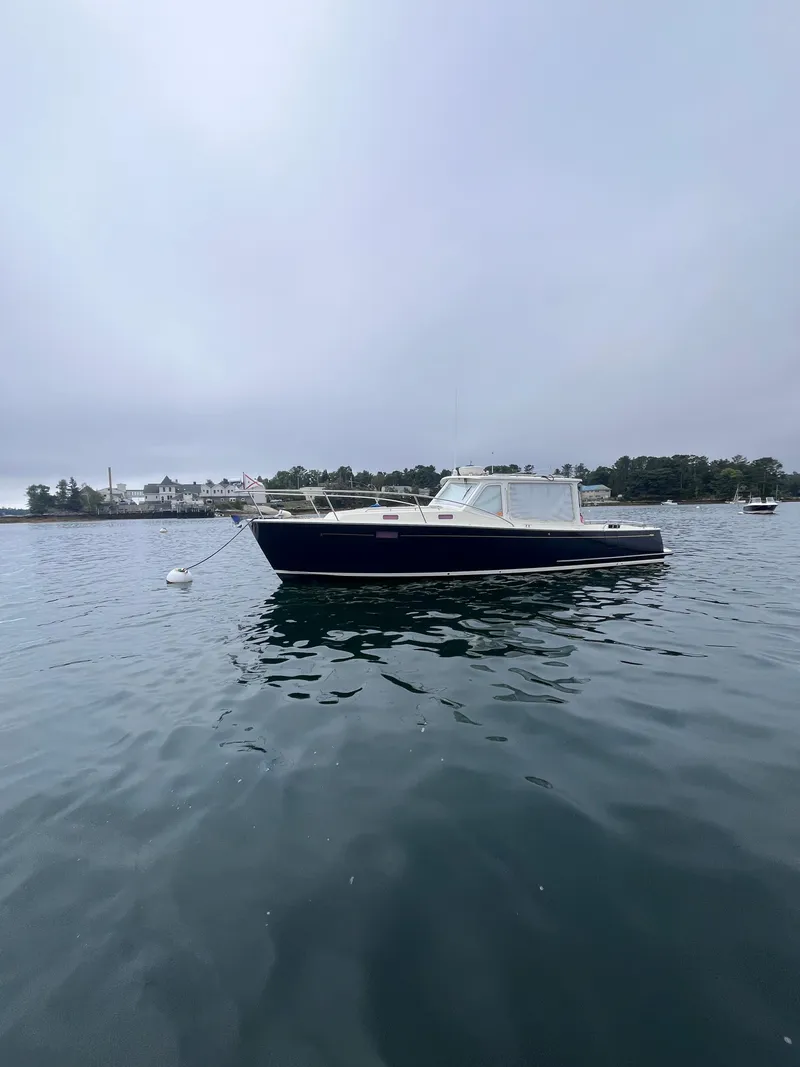 Slide: The Image of 2014 MJM 36z Downeast boat moored on calm water under cloudy sky. - 24