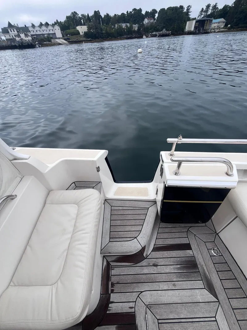 Slide: The Image of 2014 MJM 36z Downeast boat with white seating and wooden deck by the water. - 28