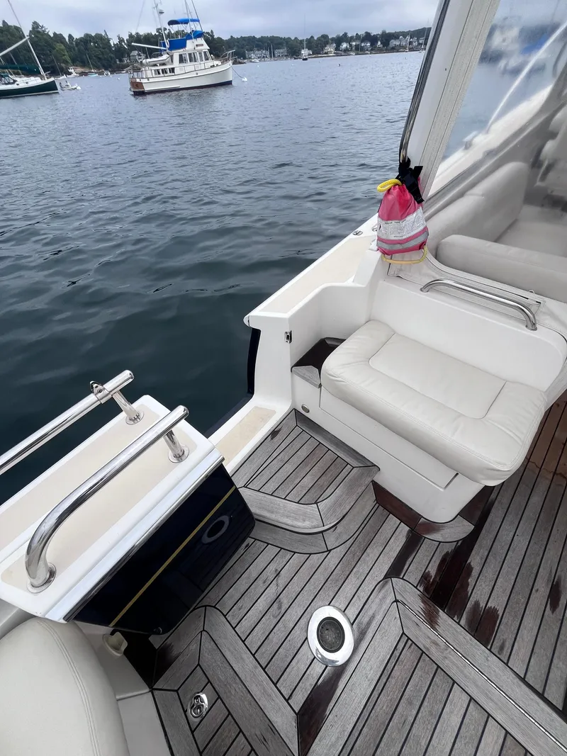 Slide: The Image of 2014 MJM 36z Downeast boat interior with white seating and wooden deck. - 29