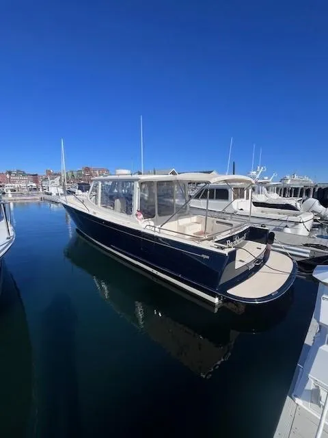Slide: The Image of 2014 MJM 36z Downeast boat docked in marina under clear blue sky. - 9