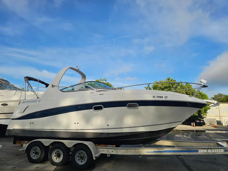 Slide: The Image of 2002 Four Winns 248 Vista boat on trailer under blue sky. - 1
