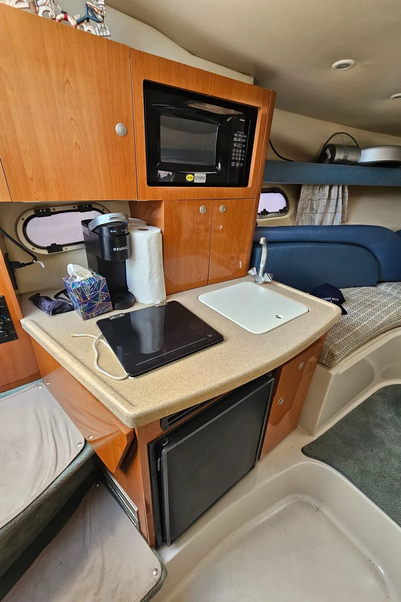 Slide: The Image of 2002 Four Winns 248 Vista boat interior with kitchenette, microwave, and sink. - 12